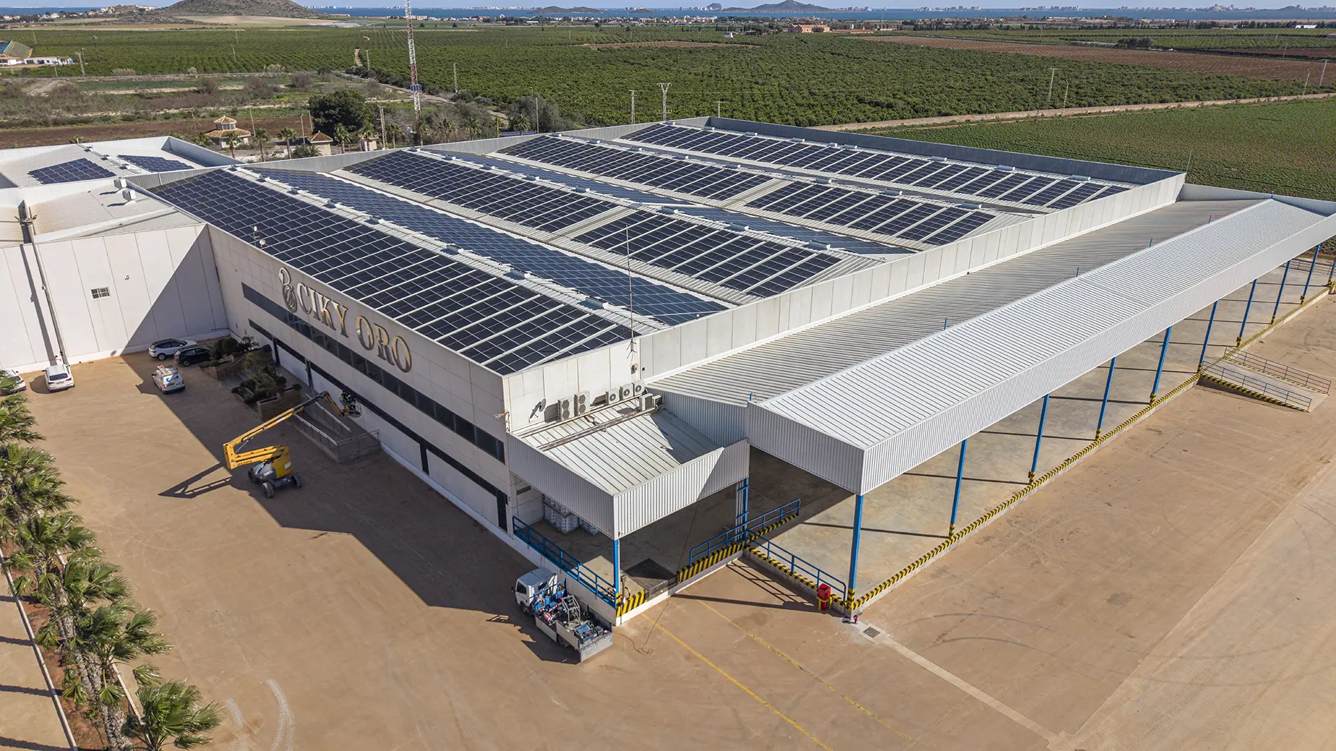 Vista aérea de instalación de autoconsumo fotovoltaico industrial 1.035 kWp en nave de Ciky Oro, Murcia, por Grupo Luna